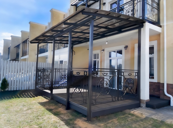 Навес пристрой к дому с крышей из прозрачного поликарбоната и ограждениями Навес пристрой к дому с крышей из прозрачного поликарбоната и ограждениями